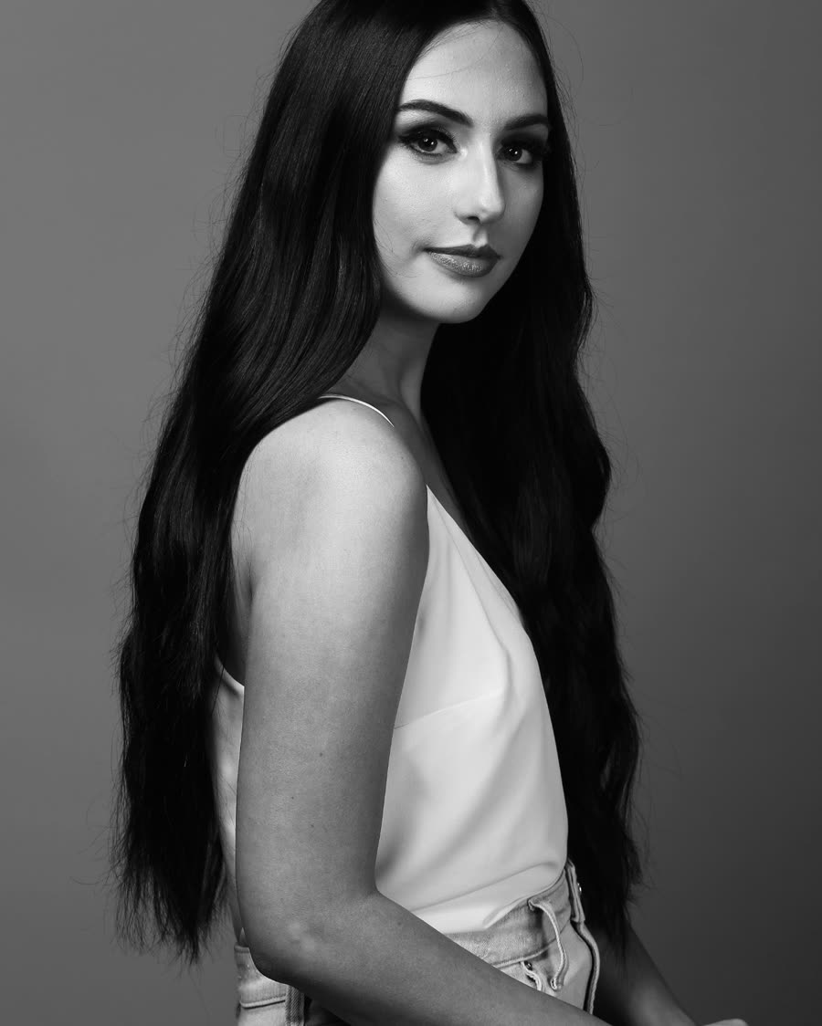 Dark tape-in extensions worn long and straight, side profile