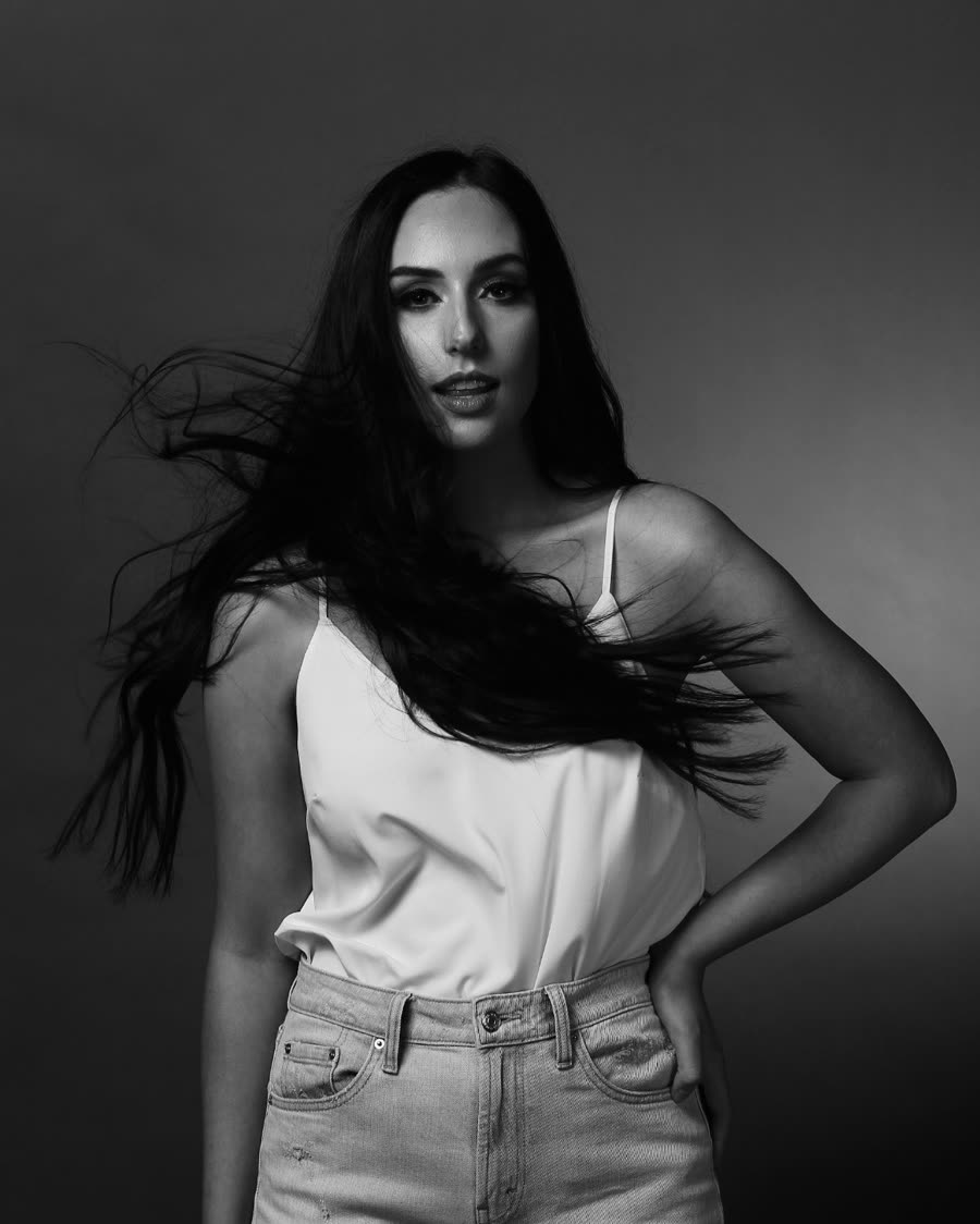 Dark tape-in extensions in movement against a studio backdrop